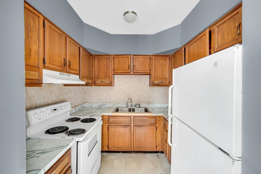 7017 South Merrill Avenue, Unit 305 Chicago, IL 60649 - Photo 16 of 20 a kitchen with a sink a stove and refrigerator