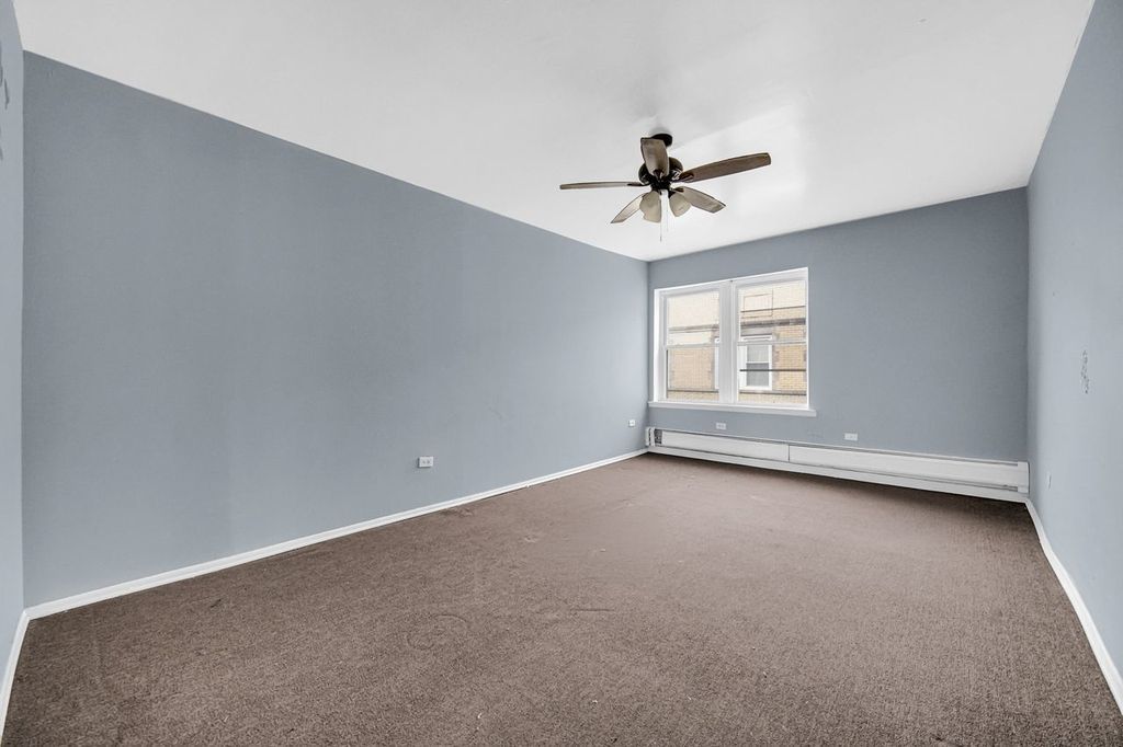 7017 South Merrill Avenue, Unit 305 Chicago, IL 60649 - Photo 19 of 20 a view of a livingroom with a ceiling fan and window