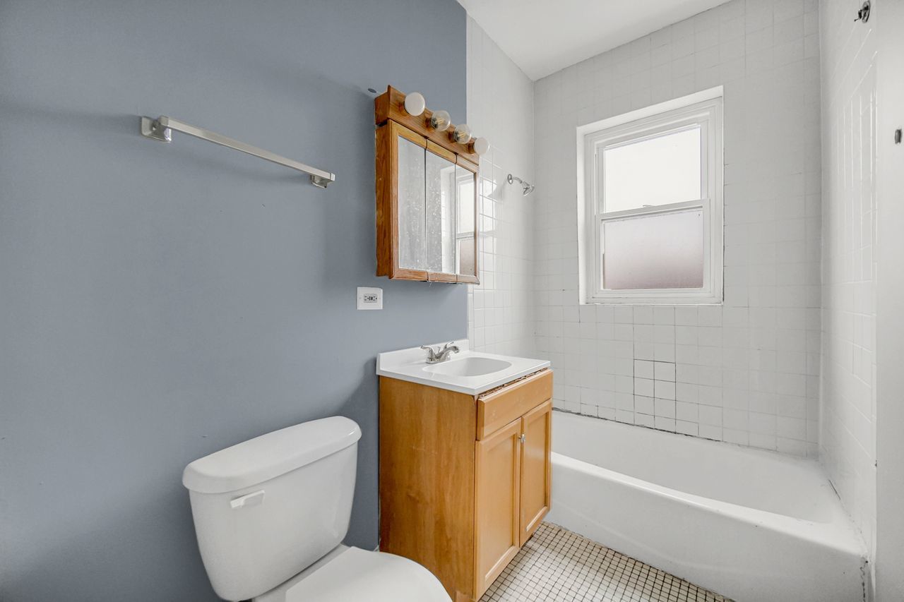 7017 South Merrill Avenue, Unit 305 Chicago, IL 60649 - Photo 20 of 20 a bathroom with a toilet sink and bathtub