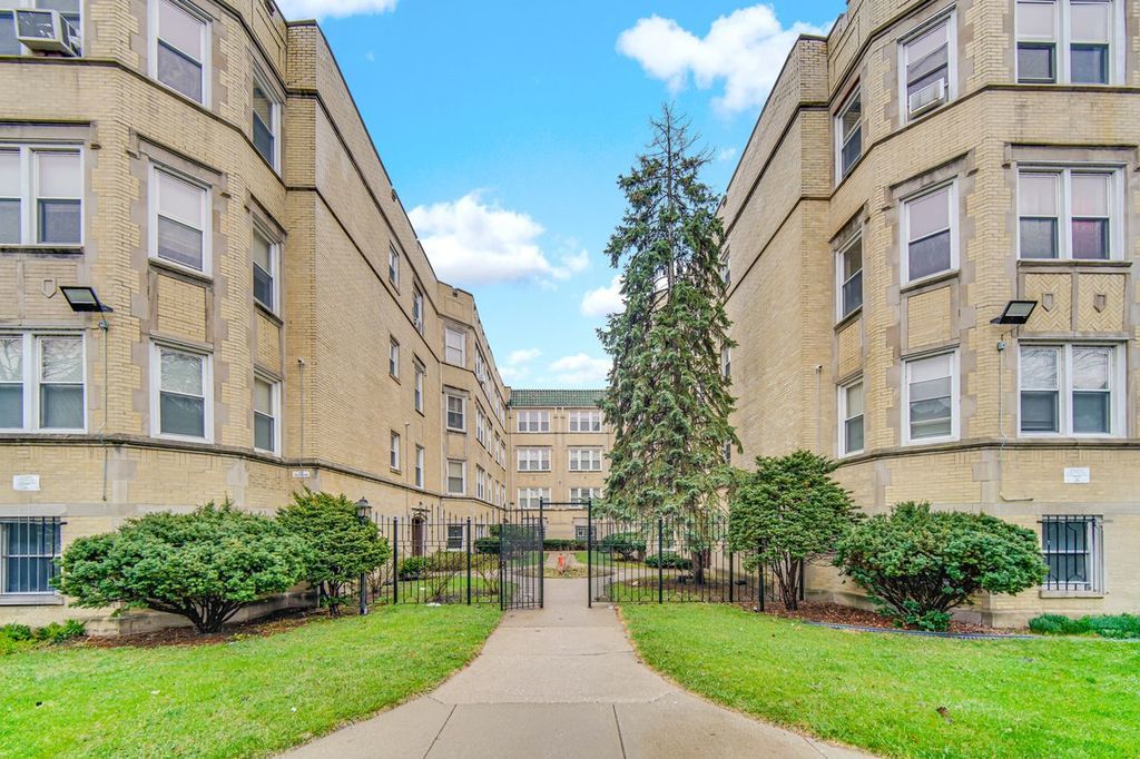 7017 South Merrill Avenue, Unit 305 Chicago, IL 60649 - Photo 3 of 20 a view of a building with a yard