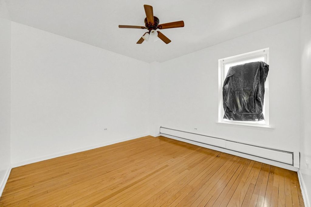 7017 South Merrill Avenue, Unit 305 Chicago, IL 60649 - Photo 6 of 20 a view of a room with a window and wooden floor