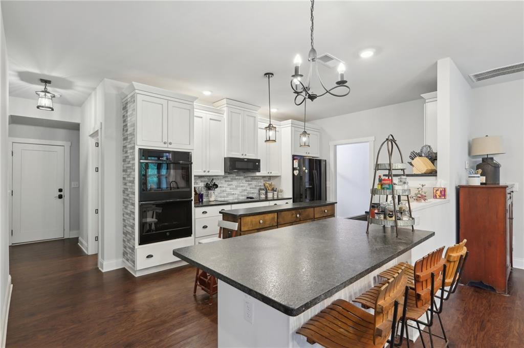 411 Johnson Road Locust Grove, GA 30248 - Photo 12 of 54 a kitchen with stainless steel appliances granite countertop a stove refrigerator and cabinets