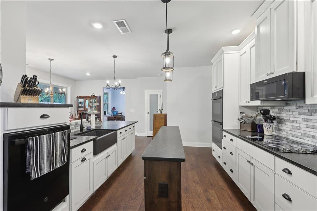 411 Johnson Road Locust Grove, GA 30248 - Photo 14 of 54 a large kitchen with stainless steel appliances lots of counter space and wooden floor