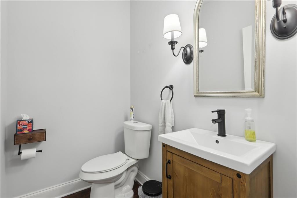 411 Johnson Road Locust Grove, GA 30248 - Photo 19 of 54 a bathroom with a toilet a sink and mirror