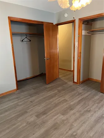 an empty room with wooden floor and a ceiling fan