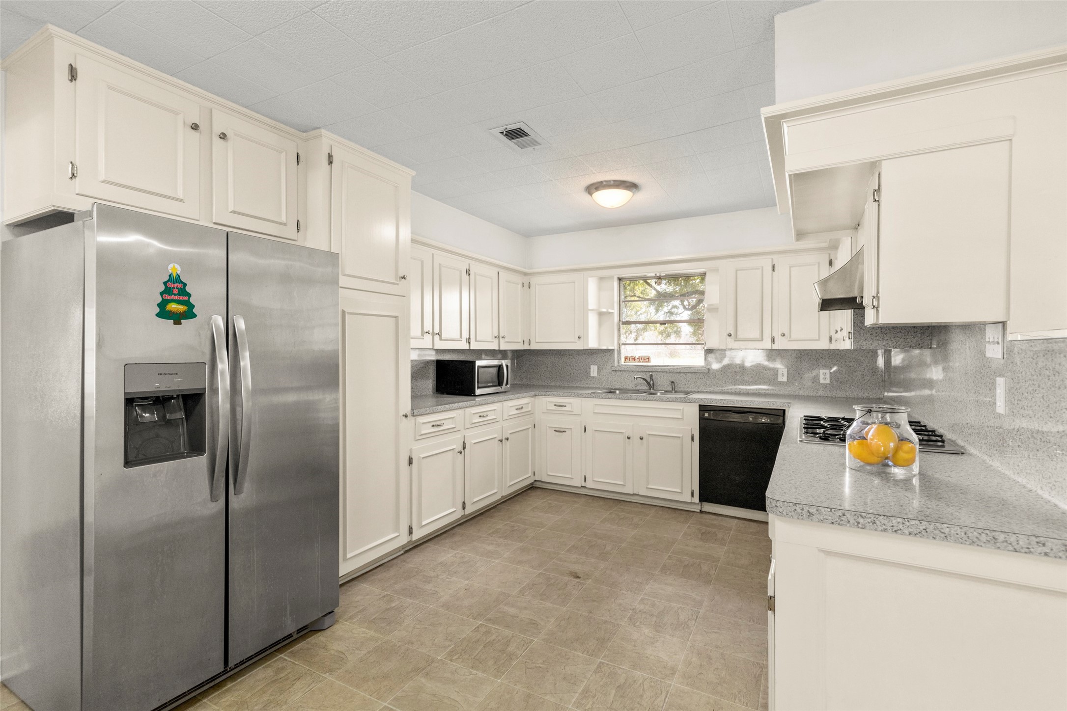 9001 Friendship Road Houston, TX 77080 - Photo 5 of 22 a kitchen with stainless steel appliances a refrigerator sink and white cabinets