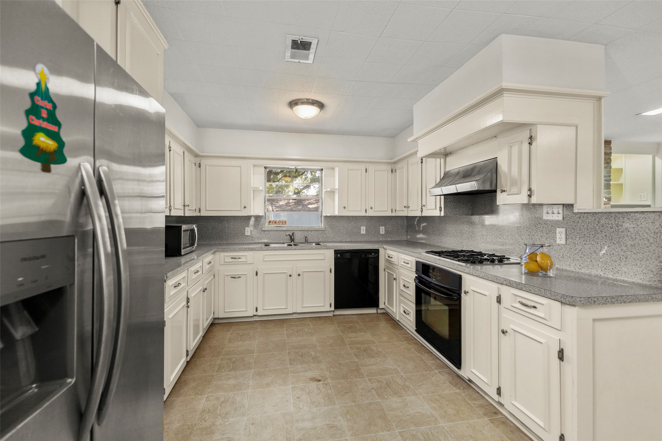 9001 Friendship Road Houston, TX 77080 - Photo 6 of 22 a kitchen with refrigerator a sink a stove a microwave and cabinets