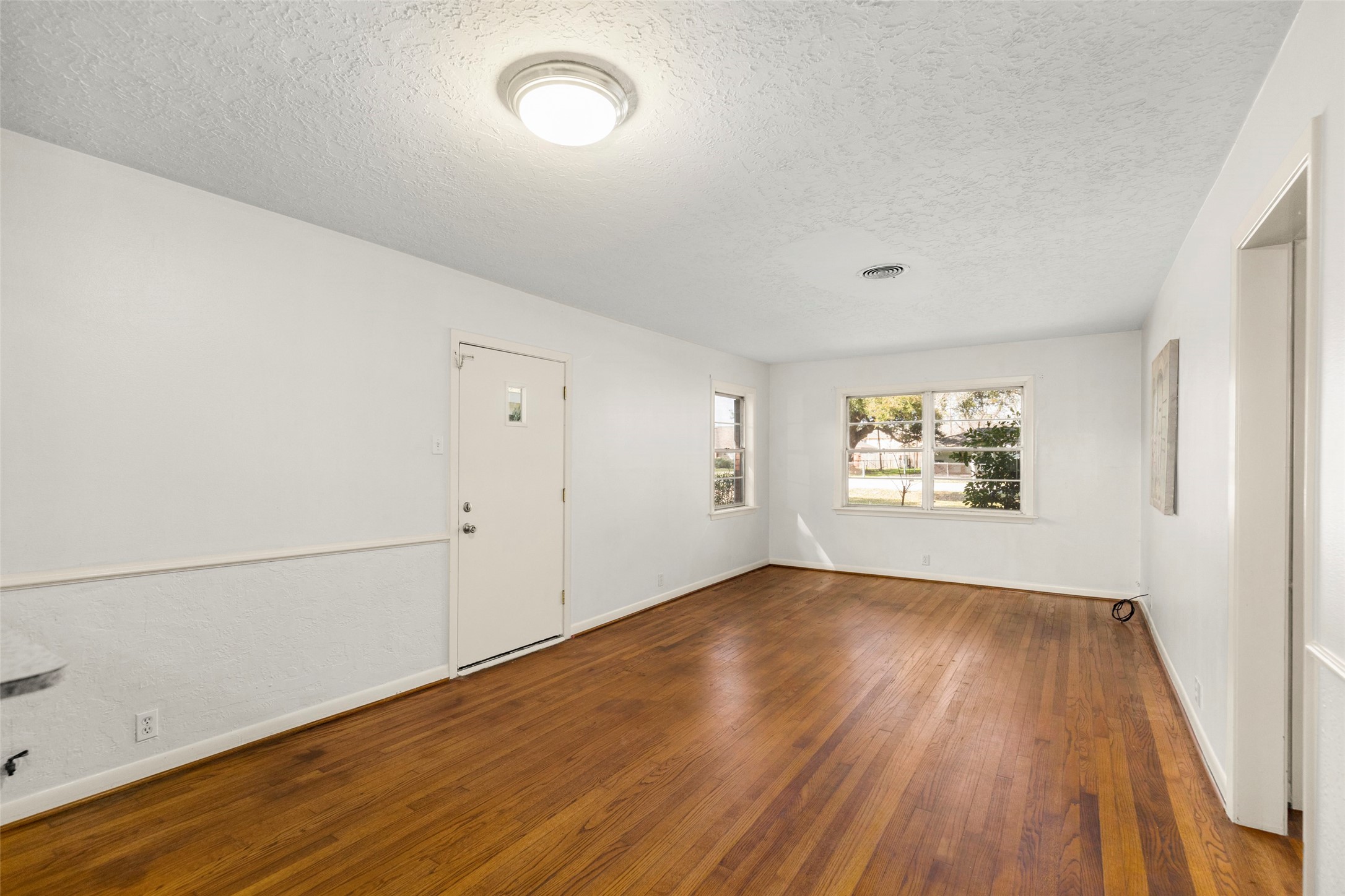 9001 Friendship Road Houston, TX 77080 - Photo 8 of 22 an empty room with wooden floor and windows