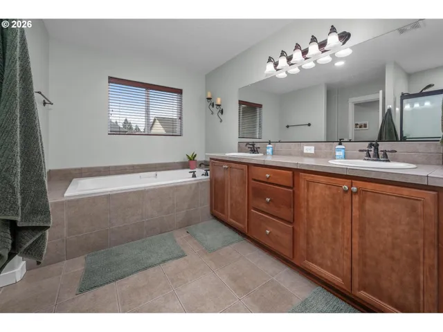 a bathroom with a granite countertop sink a large mirror and a shower