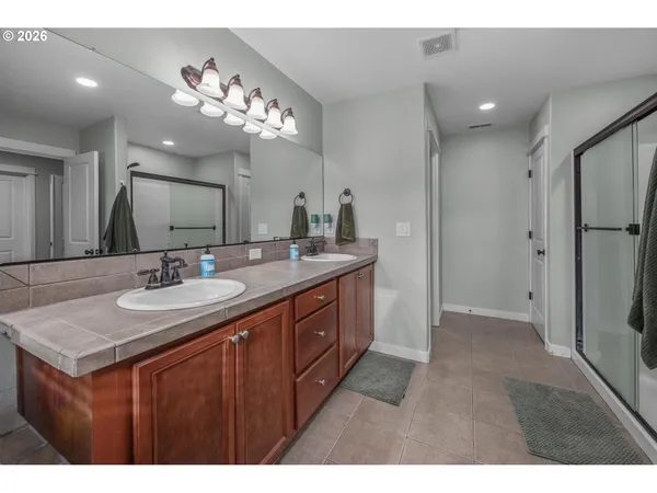 a bathroom with a tub sink shower and mirror
