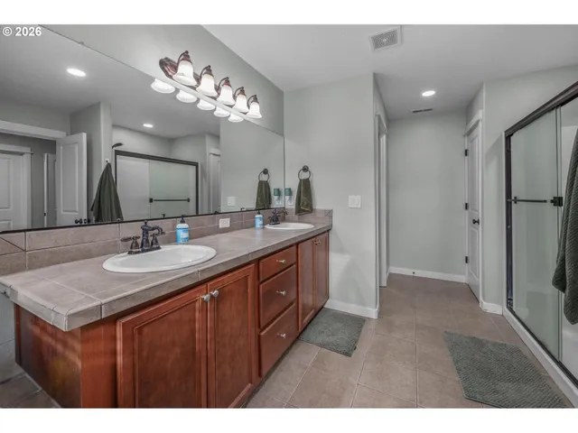 a bathroom with a tub sink shower and mirror