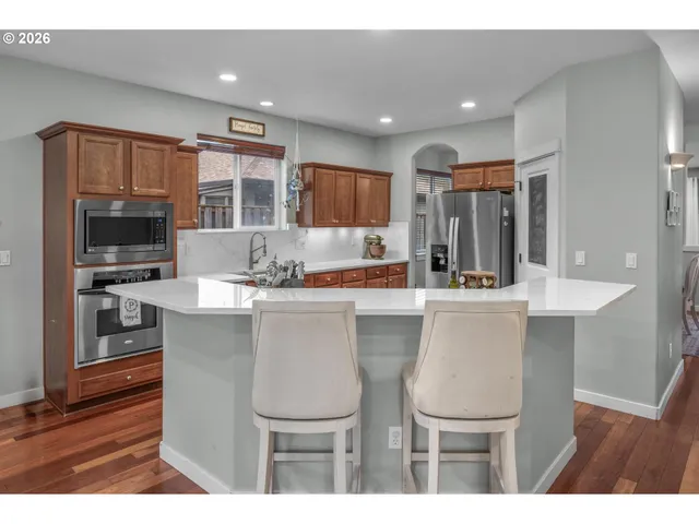 a kitchen with a table chairs refrigerator and microwave