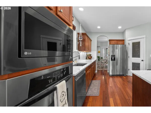 a open kitchen with stainless steel appliances a refrigerator and a wooden cabinets