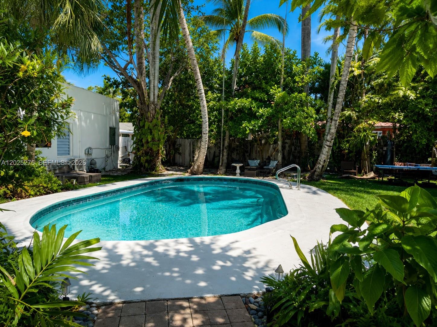 1329 Tyler Street Hollywood, FL 33019 - Photo 6 of 10 a view of a swimming pool and trees in the background