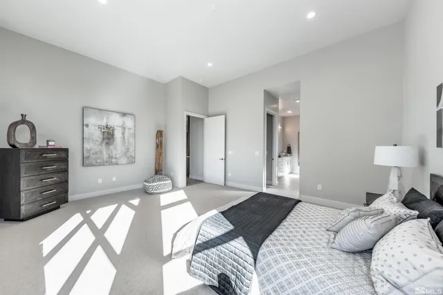 a bedroom with a large bed and a chandelier