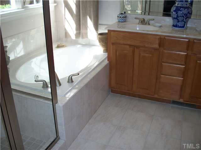 7318 Fontana Ridge Lane Raleigh, NC 27613 - Photo 12 of 23 Owners bath with high vanity tops, double bowls, whirlpool tub/sep shower, extra built in linen closet, custom tiled floor and upgraded lighting