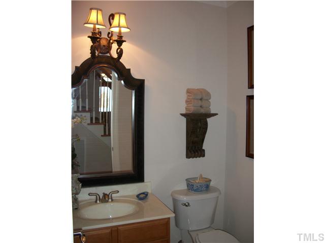 7318 Fontana Ridge Lane Raleigh, NC 27613 - Photo 9 of 23 Powder room off the hallway with hardwood floors, maple vanity and custom lighting