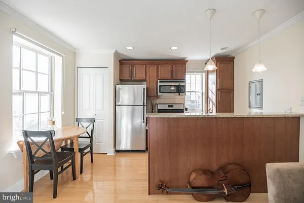 a kitchen with stainless steel appliances granite countertop a refrigerator a stove a sink dishwasher with a dining table and chairs