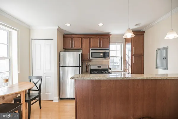 a kitchen with stainless steel appliances a refrigerator and a stove top oven