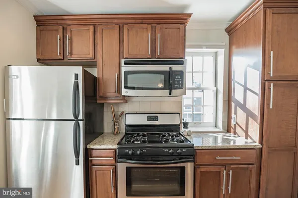 a kitchen with refrigerator a stove a microwave and cabinets