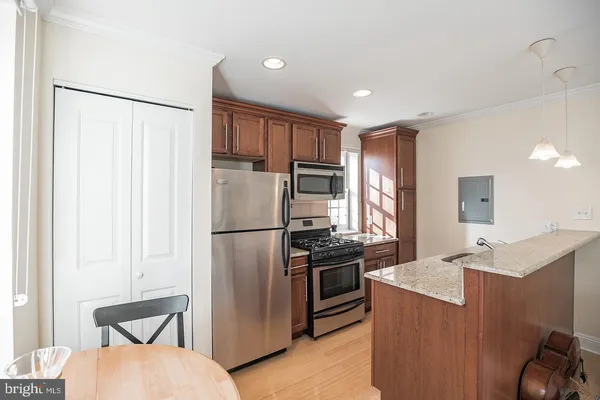 a kitchen with stainless steel appliances granite countertop a refrigerator and a stove top oven