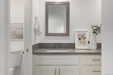 a bathroom with a granite countertop sink and a mirror