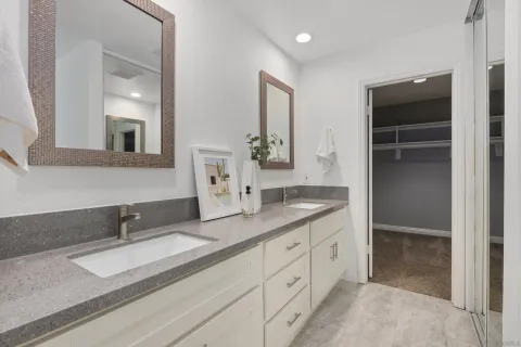 a bathroom with double sink and a mirror