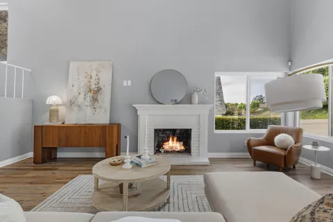 a living room with furniture a fireplace and a large window