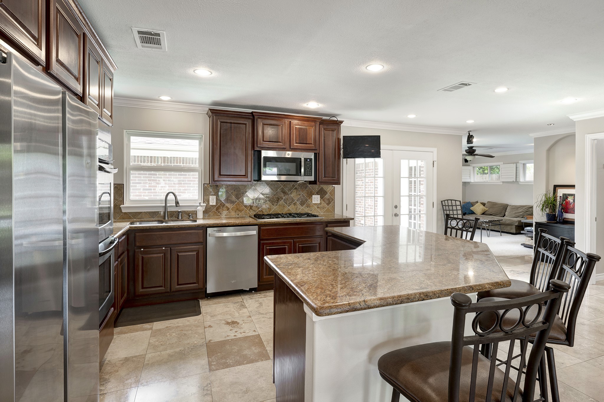 1111 Clovis Road Houston, TX 77008 - Photo 6 of 32 The nicely appointed kitchen features granite countertops, cherry wood cabinetry, a stainless-steel appliance package and a breakfast bar with seating that can accommodate 4-6 chairs.