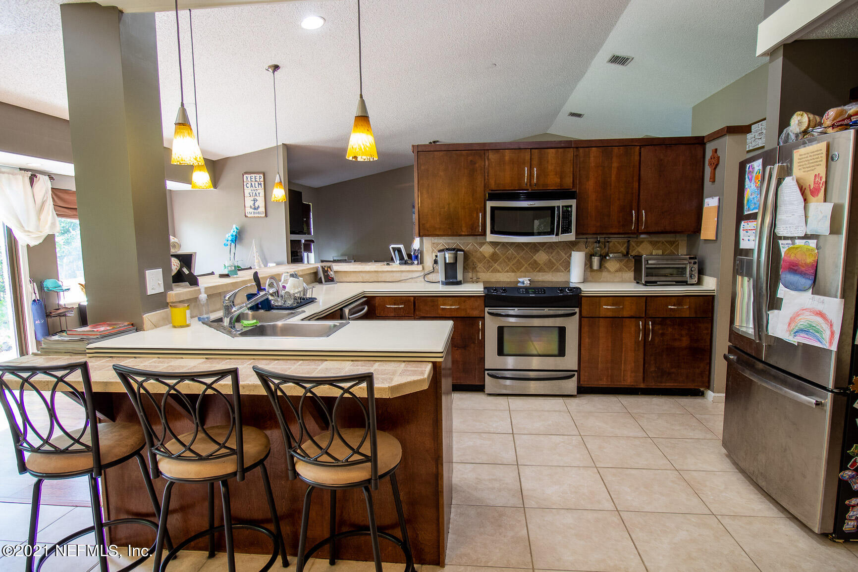 2159 Deer Run Trail Jacksonville, FL 32246 - Photo 10 of 15 a kitchen with stainless steel appliances a stove a sink refrigerator and a microwave