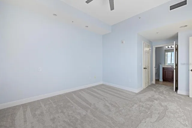 a bathroom with a granite countertop sink a toilet a mirror and shower