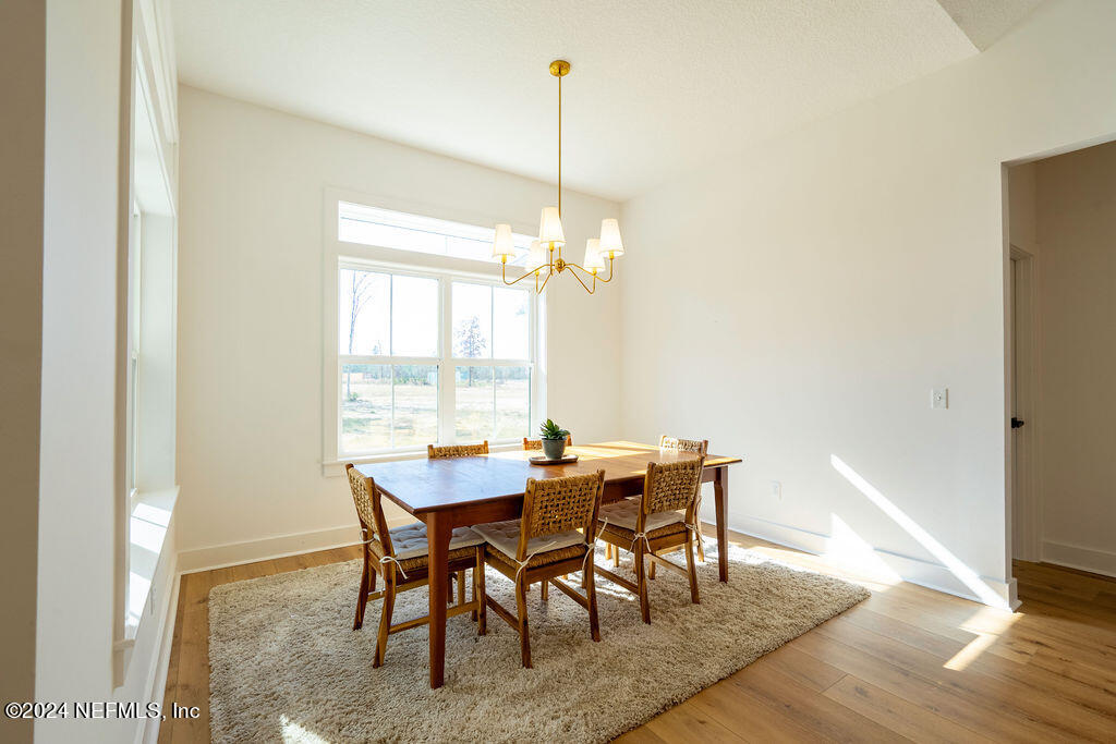 35364 Quail Road Callahan, FL 32011 - Photo 17 of 40 a dining room with furniture a chandelier and wooden floor