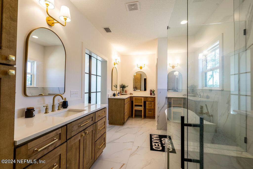 35364 Quail Road Callahan, FL 32011 - Photo 23 of 40 a bathroom with a double vanity sink a toilet a mirror and shower