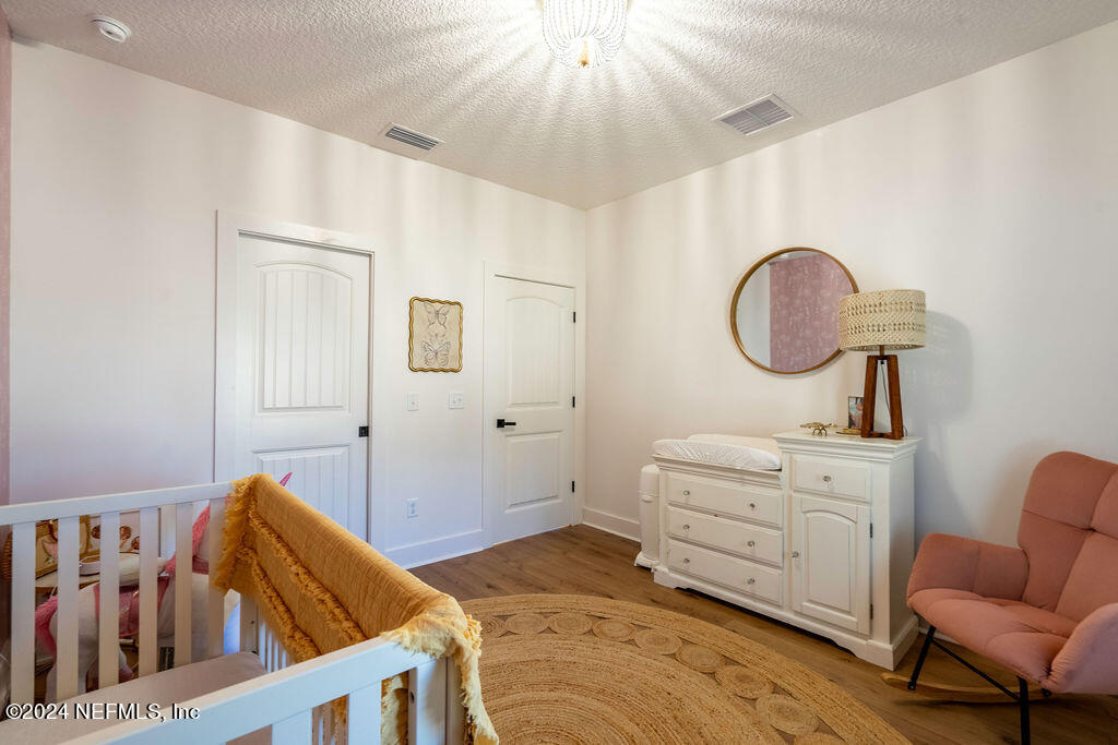 35364 Quail Road Callahan, FL 32011 - Photo 32 of 40 a bedroom with a bed a chandelier and dresser