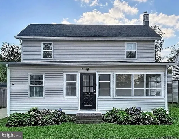 a view of a house with potted plants and a garden