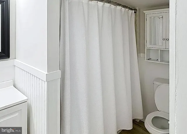 a white toilet sitting next to a shower
