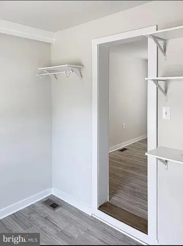 a view of walk in closet with empty racks
