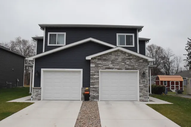 a front view of a house with a garden and garage