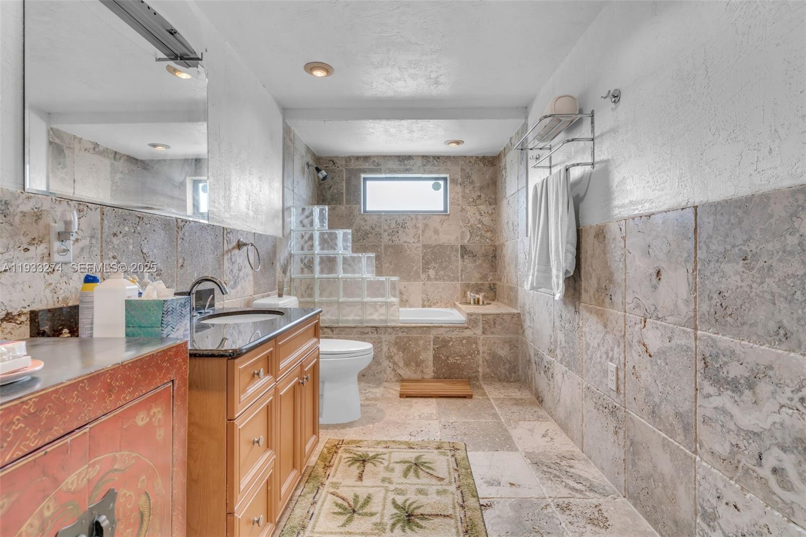 18900 Southwest 224th Street Miami, FL 33170 - Photo 17 of 23 a bathroom with a granite countertop sink a toilet a mirror and shower