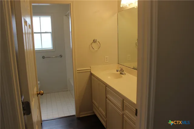 a bathroom with a granite countertop sink and a mirror
