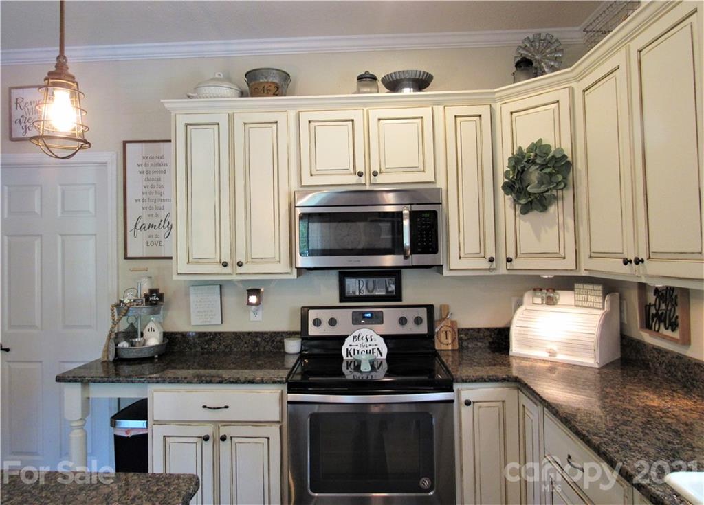 66 High Acres Road Waynesville, NC 28786 - Photo 11 of 41 a kitchen with stainless steel appliances granite countertop a stove a sink and a microwave