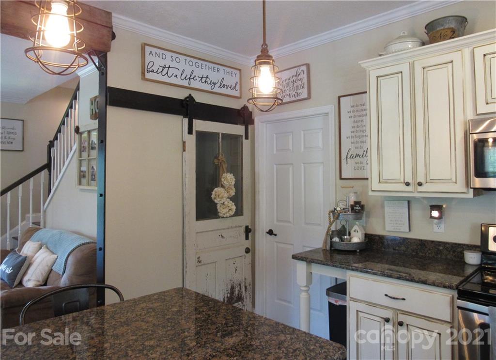 66 High Acres Road Waynesville, NC 28786 - Photo 12 of 41 a kitchen with granite countertop a sink a stove and cabinets