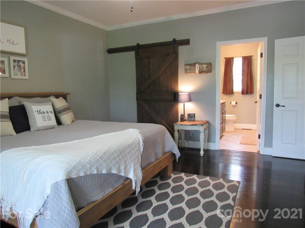 66 High Acres Road Waynesville, NC 28786 - Photo 15 of 41 a bedroom with a bed and wooden floor