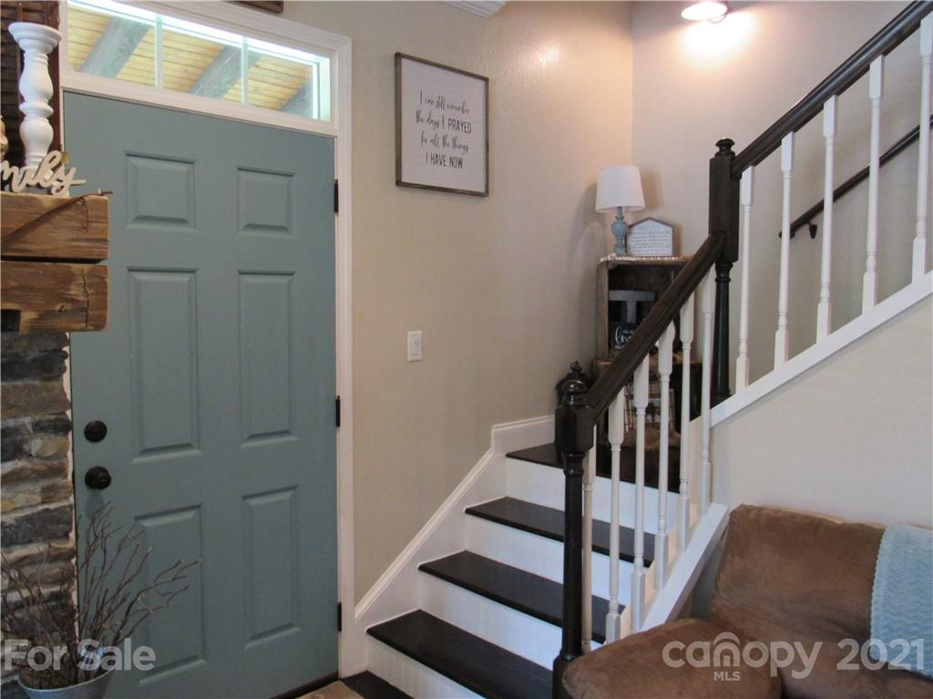 66 High Acres Road Waynesville, NC 28786 - Photo 17 of 41 a view of staircase with lots of frames on wall and a window