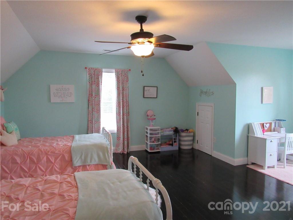 66 High Acres Road Waynesville, NC 28786 - Photo 18 of 41 a bedroom with a bed and a chandelier