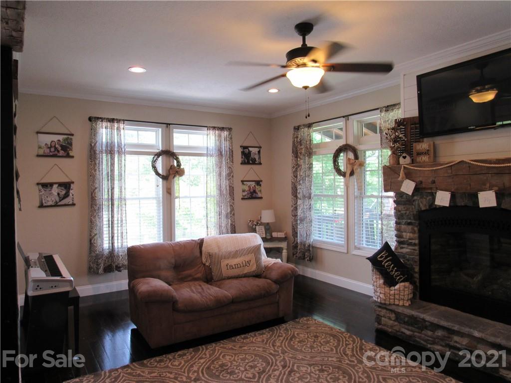 66 High Acres Road Waynesville, NC 28786 - Photo 3 of 41 a living room with furniture a fireplace and a flat screen tv