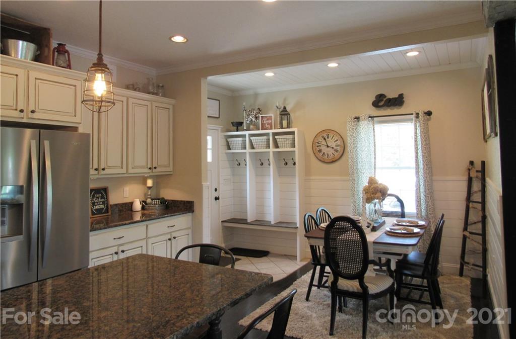 66 High Acres Road Waynesville, NC 28786 - Photo 7 of 41 a kitchen with granite countertop a table chairs stove and refrigerator
