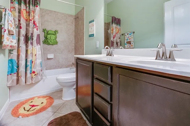 a bathroom with a sink a toilet and shower curtain