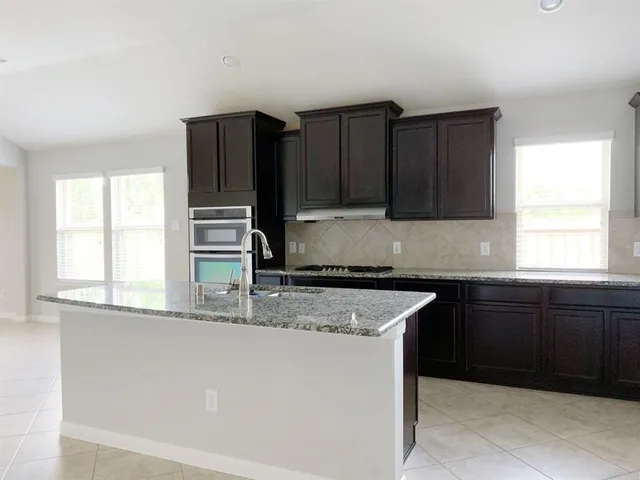 a kitchen with granite countertop wooden cabinets and a sink