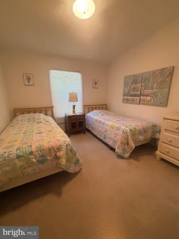 a bedroom with two beds and window